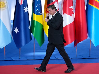 Bolsonaro tira a máscara para posar ao lado de Mario Draghi na chegada à cúpula do G20, em Roma, neste sábado.