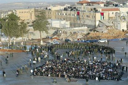 Rezos &mdash;de cara a la meca&mdash; en la explanada de la Mukata, en Ramala, para celebrar el fin del Ramadán. Al fondo a la izquierda, bajo los pinos, la tumba de Yasir Arafat.