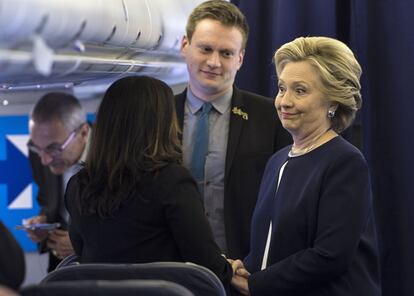 John Podesta (i), presidente de campaña de Clinton, y Teddy Goff (2d) esperan mientras la candidata demócrata, Hillary Clinton (d) habla con Maya Harris (2i) en el avión de campaña, en Westchester, Nueva York, el 4 de noviembre.