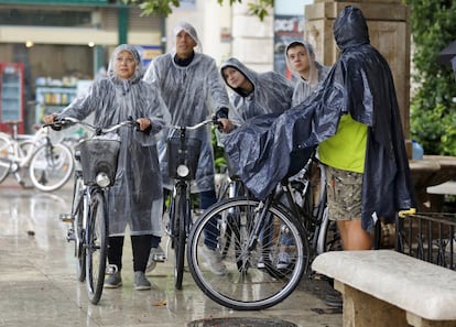 Un grupo de personas se protege de la lluvia en Valencia.