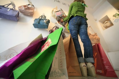 Una mujer con bolsas de compra en una tienda de Madrid.