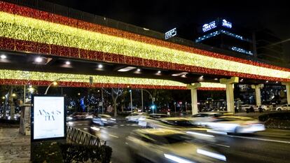 Bandera de España iluminada en el Puente Juan Bravo, en Madrid.