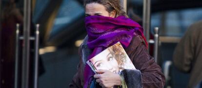 Una mujer se protege contra en frio en las calles de Madrid.