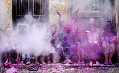 Un grupo de niños lanzan al aire polvo de colores durante las celebraciones del festival Holi en Chennai (India).