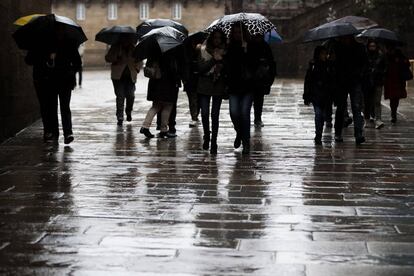 Varias personas pasean entre el viento y la lluvia, en una imagen de archivo.