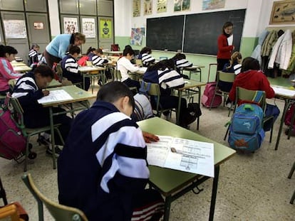 Niños valencianos atendidos por dos profesoras durante un examen.