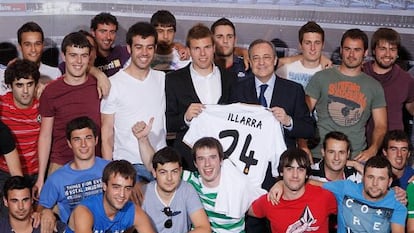 Asier Illarramendi y Florentino Pérez sostienen la nueva camiseta del centrocampista vasco, rodeados por su cuadrilla.