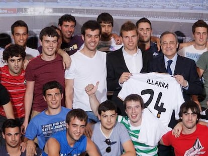 Asier Illarramendi y Florentino Pérez sostienen la nueva camiseta del centrocampista vasco, rodeados por su cuadrilla.