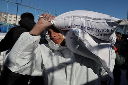 Un palestino transporta un saco de harina distribuido por la UNRWA en Rafah, al sur de la franja de Gaza.