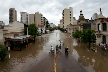 Los supervivientes cuentan que dentro de la ciudad varias calles quedaron completamente destrozadas. En la imagen, un grupo de vecinos permanecen al borde de las aguas tras el paso de la tormenta en Bahía Blanca, Argentina, el viernes 7 de marzo.