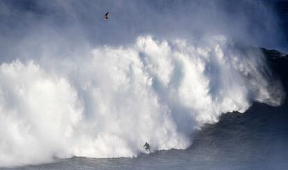 Una persona surfea una ola en Praia do Norte (Portugal).