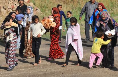 Mujeres y niños abandonan Siria tras el bombardeo en Ras Al Ain.