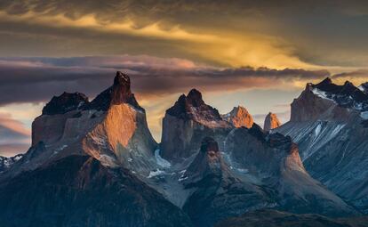 Los fuertes vientos de altura que barren la Patagonia chilena dibujan llamativas nubes que sobrevuelan uno de los grupos montañosos más bellos del mundo, los Cuernos del Paine. Durante el invierno austral, la luz ideal para fotografiarlas es la del amanecer.