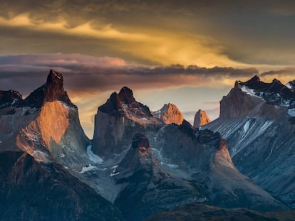 Los fuertes vientos de altura que barren la Patagonia chilena dibujan llamativas nubes que sobrevuelan uno de los grupos montañosos más bellos del mundo, los Cuernos del Paine. Durante el invierno austral, la luz ideal para fotografiarlas es la del amanecer.