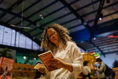 Una mujer mira un libro en el pabellón de Brasil, durante el segundo día de la feria.