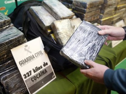 Un guardia civil muestra uno de los 327 paquetes de cocaina incautados.