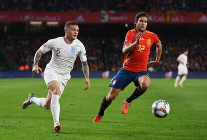 El jugador inglés, Kieran Trippier, y el jugador español, Marcos Alonso, corren para hacerse con el balón en una acción del partido.