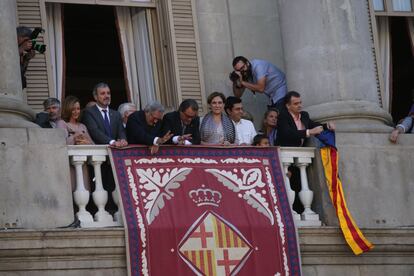 Bosch se dispone a desplegar la estelada mientras Xavier Trias y Artur Mas saludan desde el balcón.