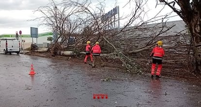 Los Bombers actuando en la calle Dinamarca de Badalona (Barcelona) por las lluvias de la tarde de este viernes.