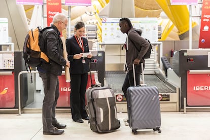 Unos pasajeros facturan en un mostrador de Iberia.