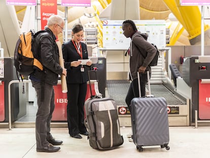 Unos pasajeros facturan en un mostrador de Iberia.