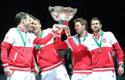 El capitán del equipo suizo, Severin Luthi, Roger Federer, Marco Chiudinelli, Stanislas Wawrinka y Michael Lammer levantan el trofeo de campeones.