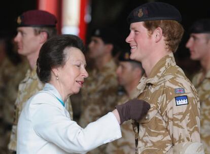 El príncipe Harry recibe la condecoración de manos de su tía, la princesa Ana de Inglaterra.