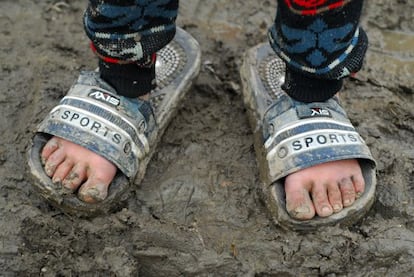 Un estudio descubrió que los niños no asistían a la escuela por problemas de diarrea. En la imagen, un niño lleva chanclas más grades que su pie.