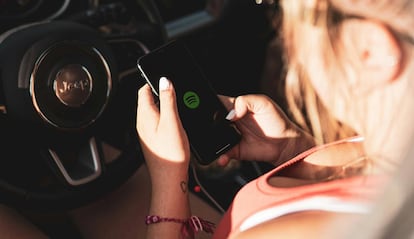 Chica utilizando Spotify en un coche