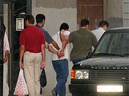 La policía se lleva esposado a un delincuente tras un tiroteo en Ciudad Lineal el pasado agosto.