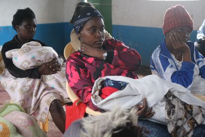 Tres madres con sus hijos en brazos atienden una formación en el centro Big5 de Nairobi, Kenia.