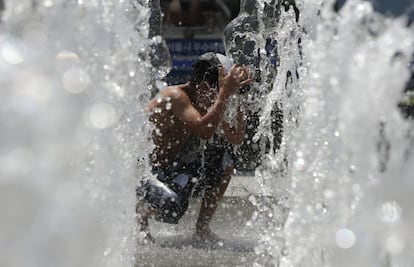 Un niño se refresca en una fuente pública en Seúl (Corea del Sur). 