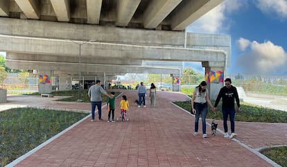 Algunas personas pasean por la zona con planteles del Parque Urbano El Dique, bajo la Autopista Siervo de la Nación (México).