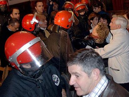 Efectivos de la Ertzaintza desalojan al público a favor de Pilar Elías, concejala de Azkoitia y viuda de Ramón Baglietto, ex concejal de UCD asesinado por ETA, durante el pleno celebrado en Azkoitia.
