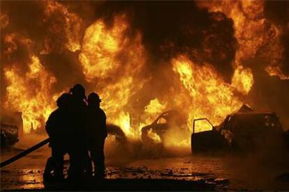 Los bomberos tratan de sofocar el incendio provocado por el atentado cerca de una gasolinera en Bagdad.