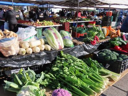 Un puesto de frutas y verduras en un mercadillo.