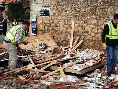 Dos guardias civiles inspeccionan el lugar donde estalló la bomba de ETA en Santillana del Mar.