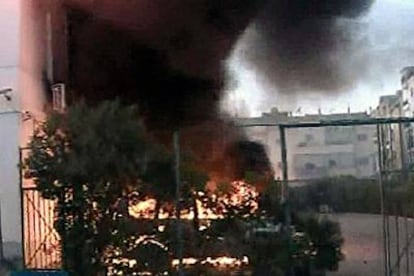 Un coche arde cerca del consulado italiano en Bengasi, al norte de Libia, ayer.