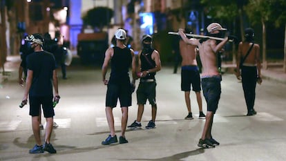 Varios jóvenes con palos y botellas, el domingo momentos antes de los enfrentamientos con la policía.
