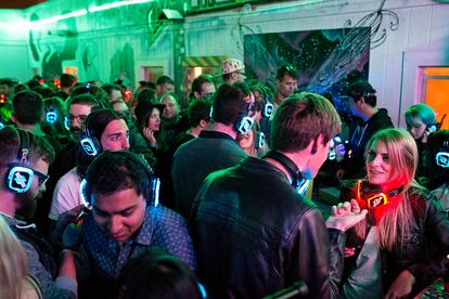 Invitados a una fiesta para celebrar el tercer aniversario de 20 Mission, una casa de co-vivienda, bailan y escuchan a un DJ pinchando música con auriculares de discoteca silenciosa en el patio del edificio durante la fiesta en San Francisco. En ese momento vivían en el edificio unas 45 personas, muchas de ellas emprendedores. Las reuniones improvisadas son frecuentes, pero las fiestas más grandes de la comunidad, que se celebran cada pocos meses, han hecho que el espacio sea muy conocido, especialmente entre la comunidad de 'start-ups'. California, 28 de marzo, 2015.