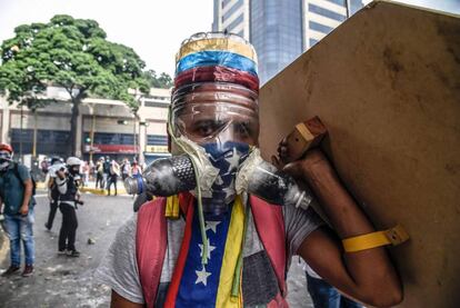 Enfrentamientos similares se produjeron en la avenida Victoria, en el oeste, y la avenida José Antonio Paéz que va del noroeste al suroeste de la ciudad. En la imagen, un joven opositor del presidente Maduro con una máscara de gas hecha con una botella.