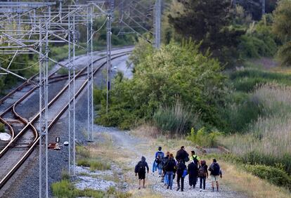 Un grupo de sirios anda cerca de una vía de tren en la región fronteriza entre Grecia y Macedonia.