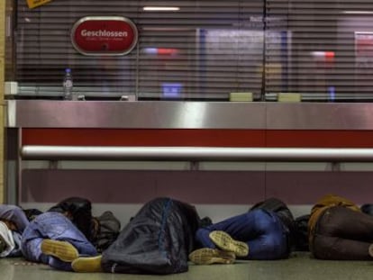 Refugiados dormem na bilheteria da estação central de Munique.