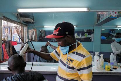 Corte de pelo en una barbería de Nairobi el pasado día 5 de mayo. El cliente debe estar en Fase 3 y el barbero en Fase 0,5.