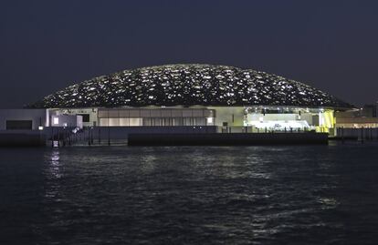 Vista noturna do museu do Louvre de Abu Dhabi. O arquiteto Jean Nouvel declarou que para ele o melhor da arquitetura árabe é unir a geometria e a luz, por isso o "sol se filtra pela cúpula como uma chuva de luz delicada e protetora refletindo a interação constante de luzes e sombras no país".