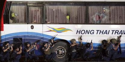 Varios agentes de la policía filipina junto al autobús secuestrado en Manila, antes del asalto