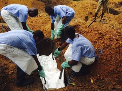 Voluntaris a Sierra Leone enterren un cos de forma segura per evitar el contagi.