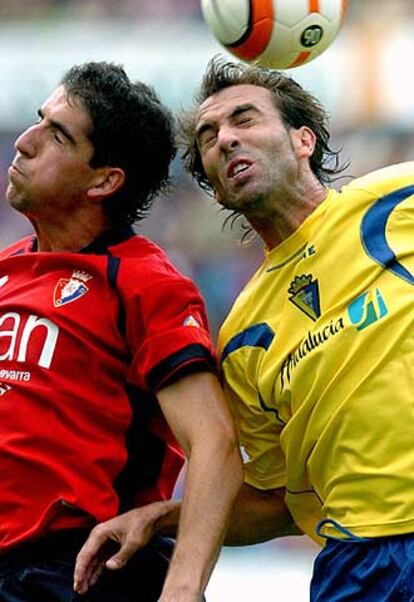 Raúl García (izquierda) salta con Raúl López en el Osasuna-Cádiz del domingo.