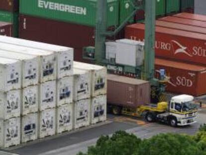 Fotografía de archivo de un camión cargando contenedores en tránsito en Tokio (Japón). Según los datos publicados hoy por el gobierno, el producto interno bruto de Japón (PIB) se contrajo un 0,4 por ciento en el periodo octubre-diciembre para el tercer trimestre consecutivo después de las exportaciones lentas.