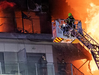 Los bomberos rescataban el jueves a una pareja que pedía ayuda desde un balcón del edificio incendiado en Valencia.